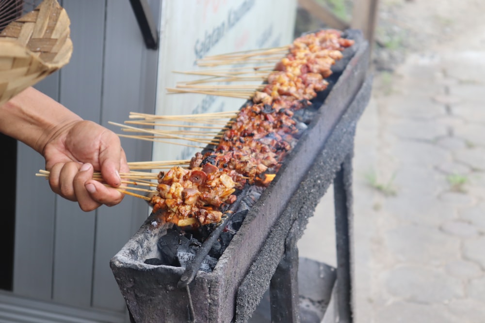 person holding brown stick with fire