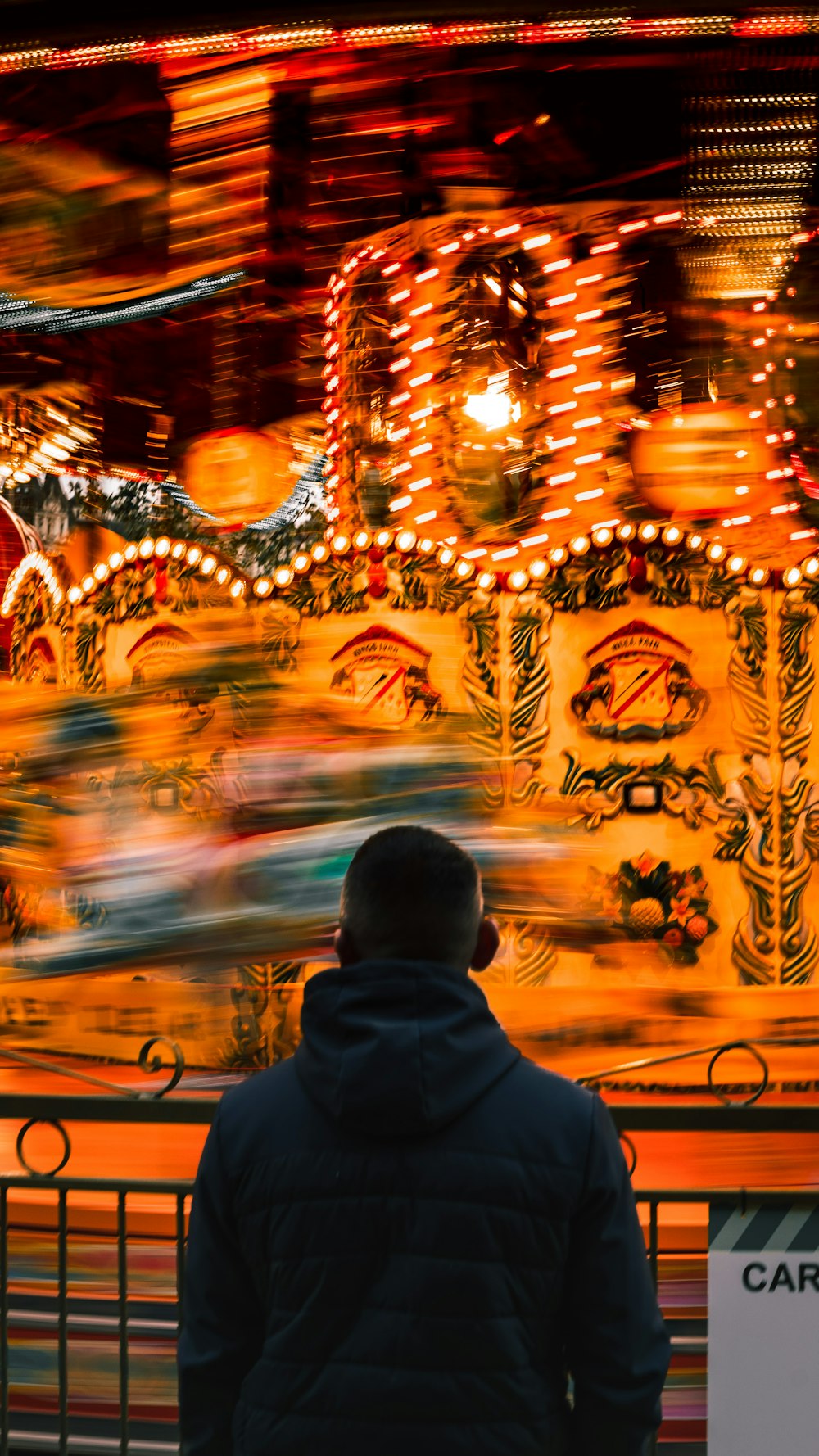 a man standing in front of a carnival ride