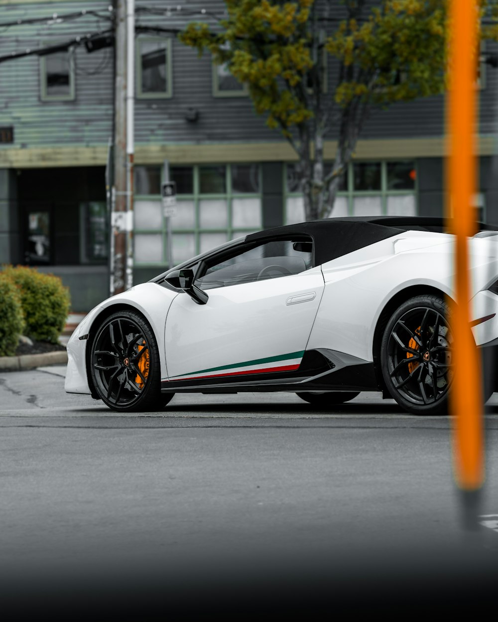 Coche descapotable negro y naranja en la carretera durante el día