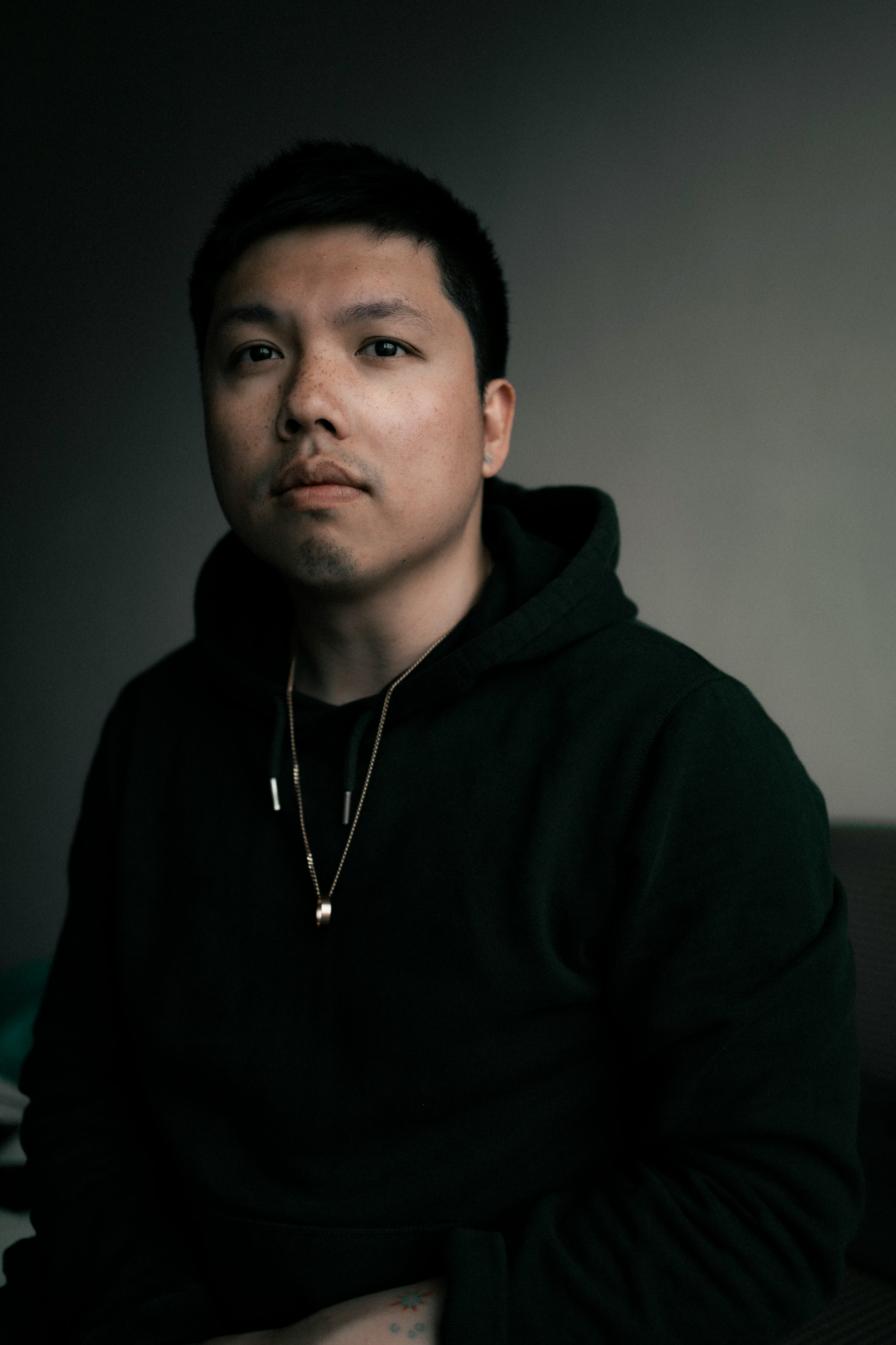 man in black hoodie wearing silver necklace