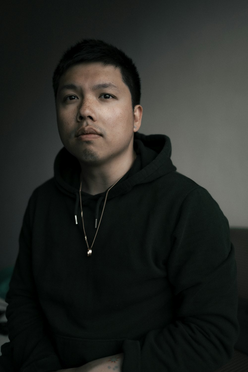 man in black hoodie wearing silver necklace