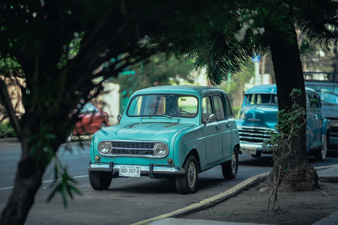 teal vintage car on road during daytime