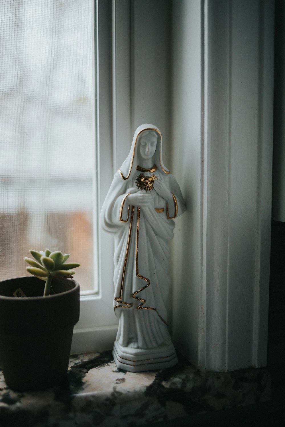 a statue of a woman next to a potted plant