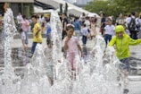Kids playing in the splash pad area with water jets and fountains at Tsunami.