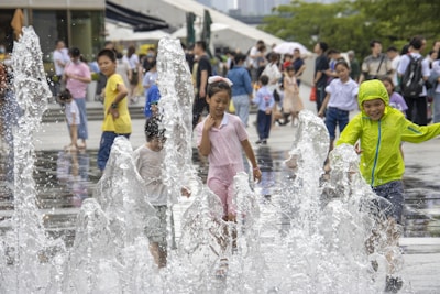 Kids playing in the splash pad area with water jets and fountains at Tsunami.