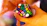 Close-up of hands twisting a colorful 3x3 rotational puzzle against a black chalkboard background.