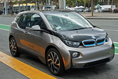 A sleek, modern compact city car parked on a sunny urban street.