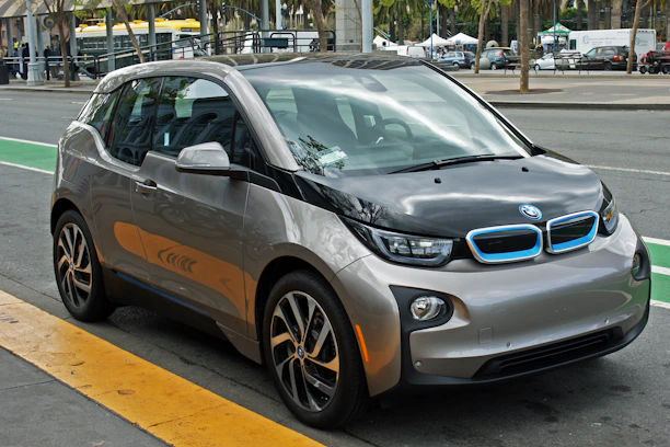 Sleek Hexa EV scooter parked on a city street, highlighting its modern design and battery compartment.