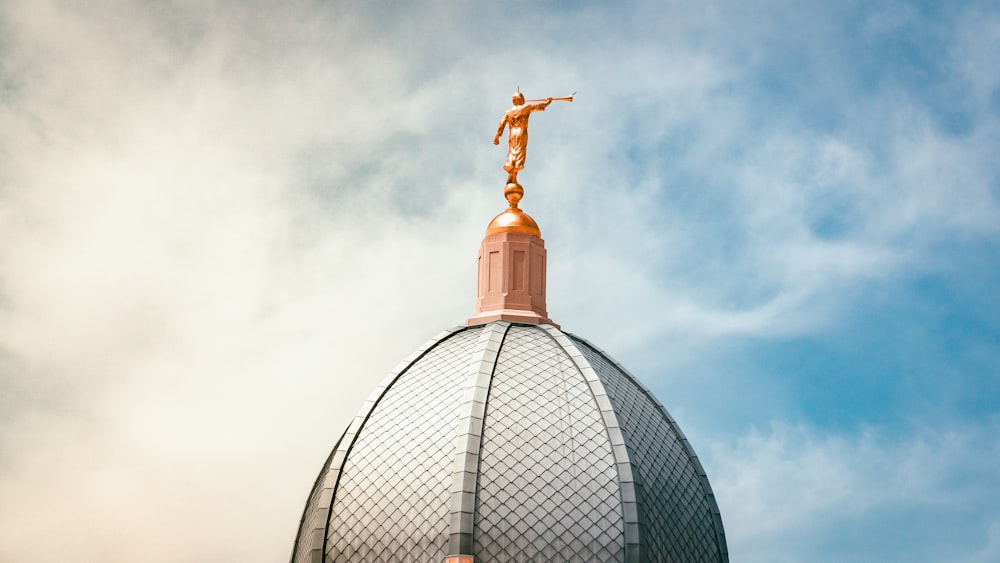 gold cross on top of gray dome building