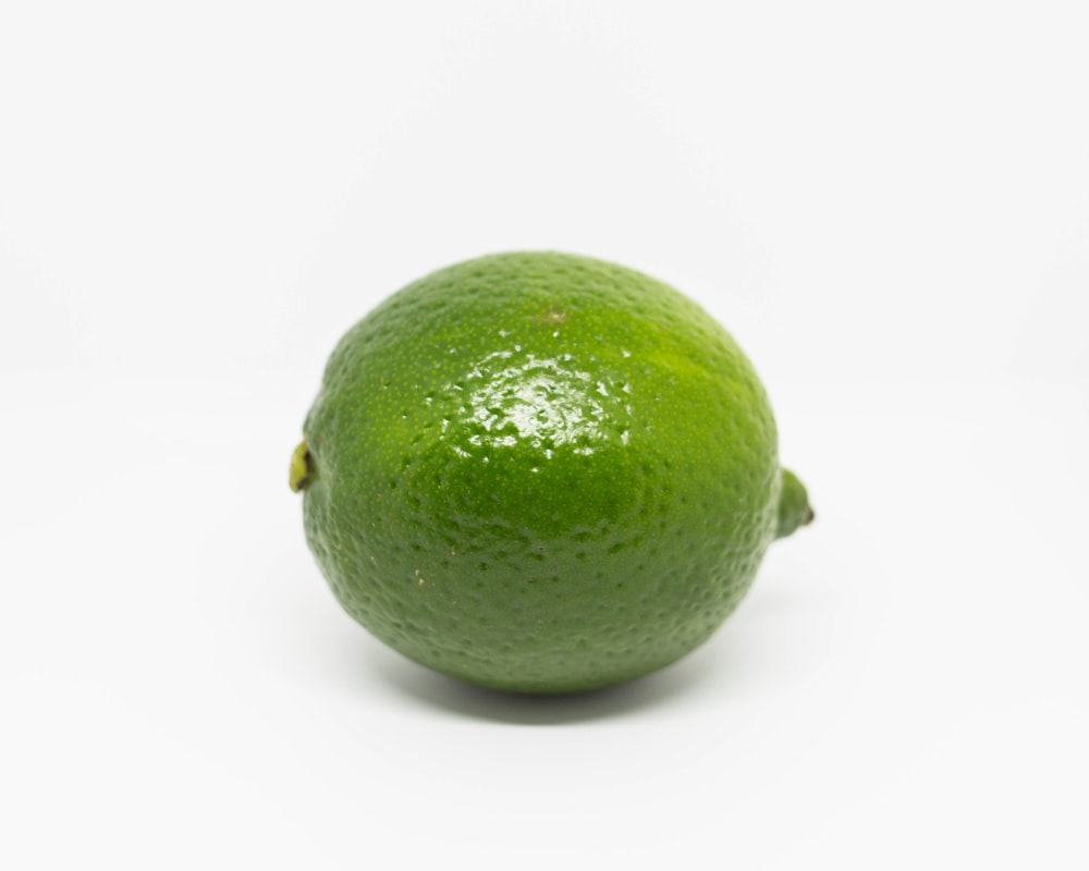 fruta verde da limão na superfície branca