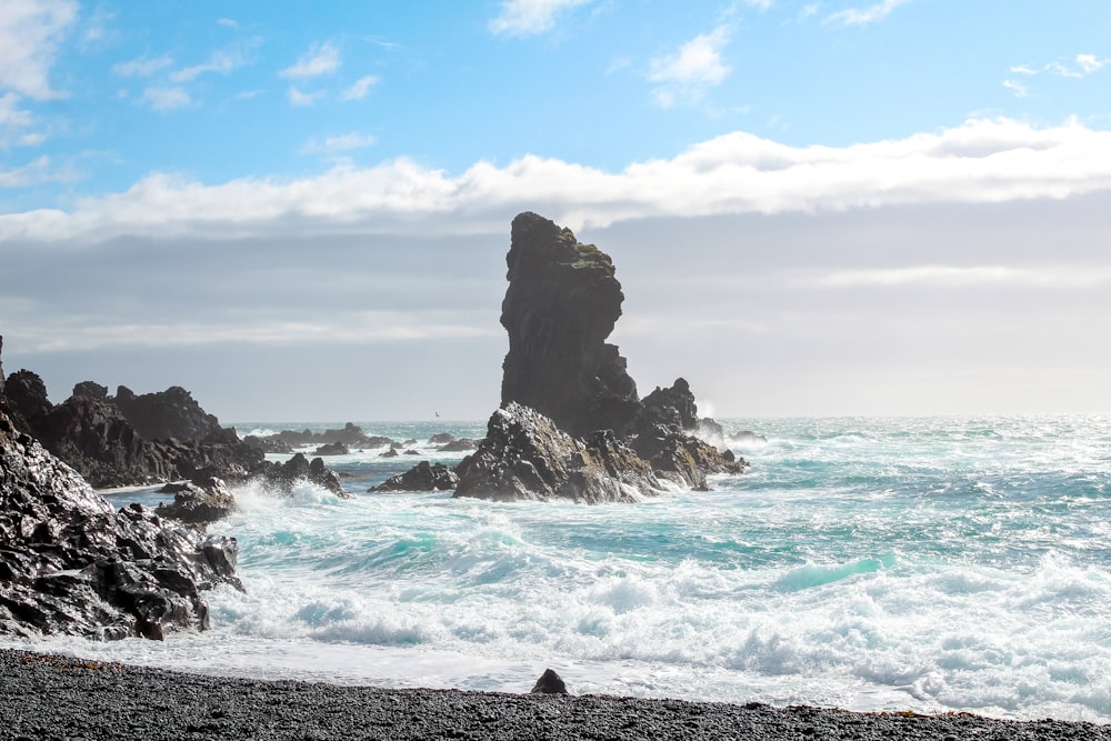 brown rock formation on sea under blue sky during daytime