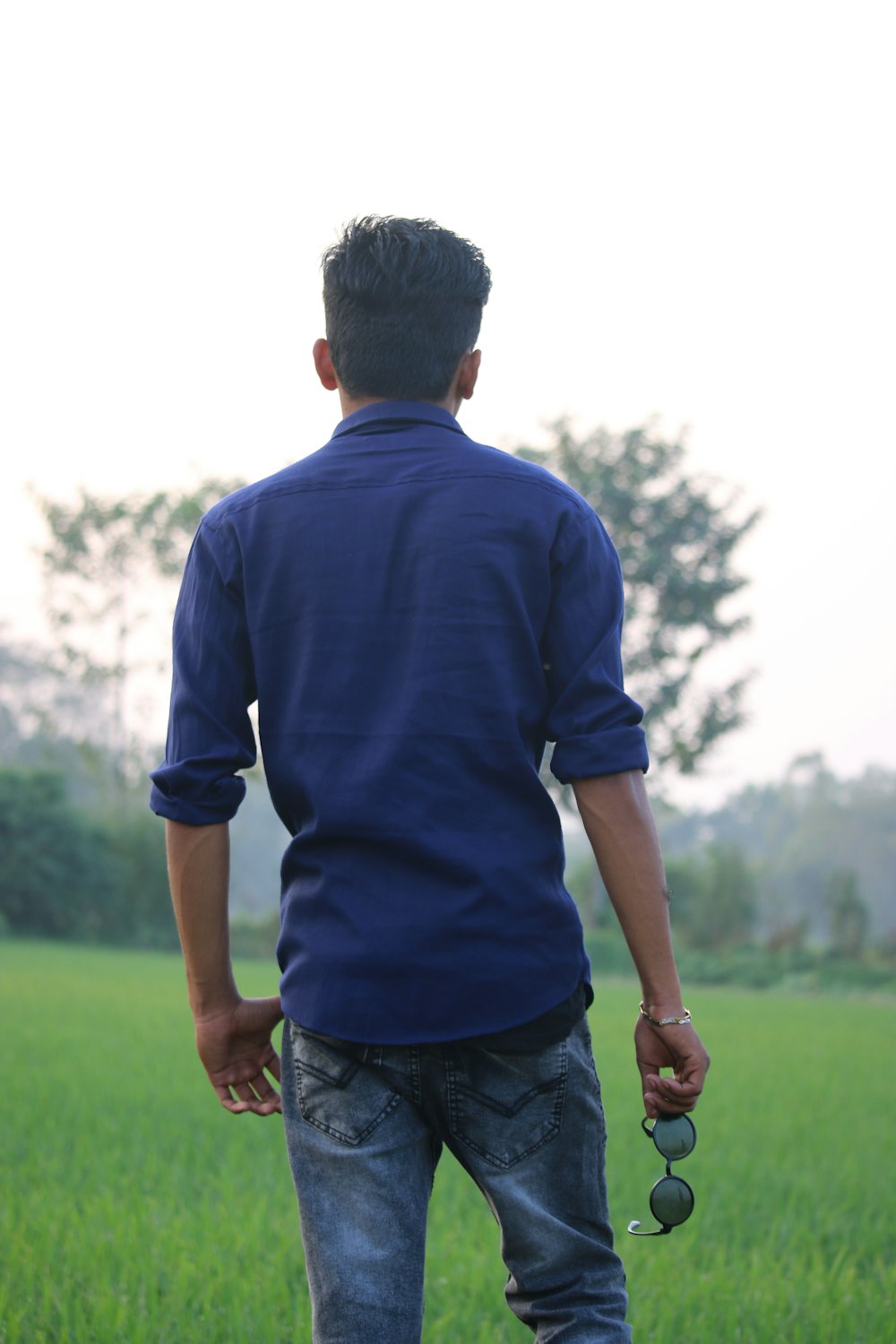 man in blue polo shirt standing on green grass field during daytime