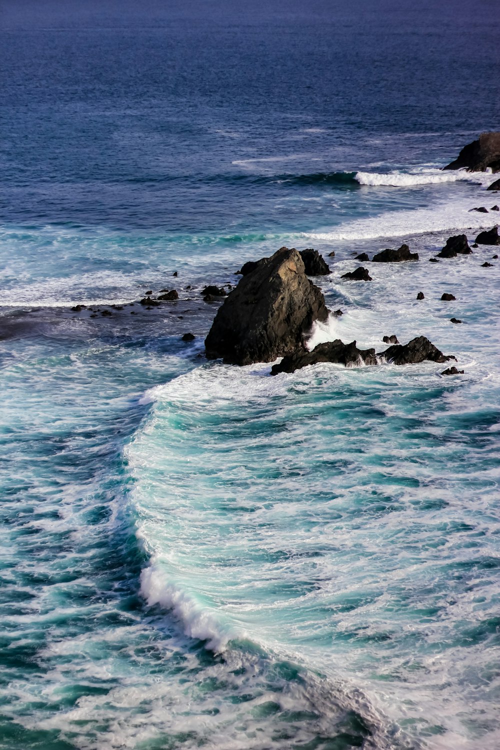 Las olas del mar rompiendo contra las rocas durante el día