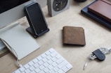 A neat workspace with a notebook, pen, and a smartphone showing budget apps.