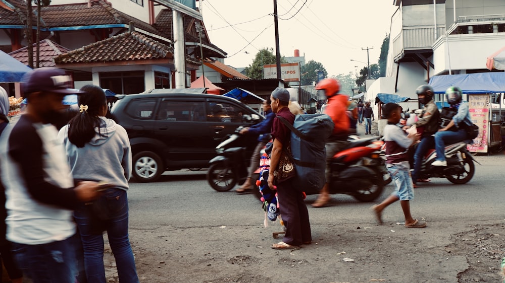 people in red and blue shirt riding motorcycle during daytime