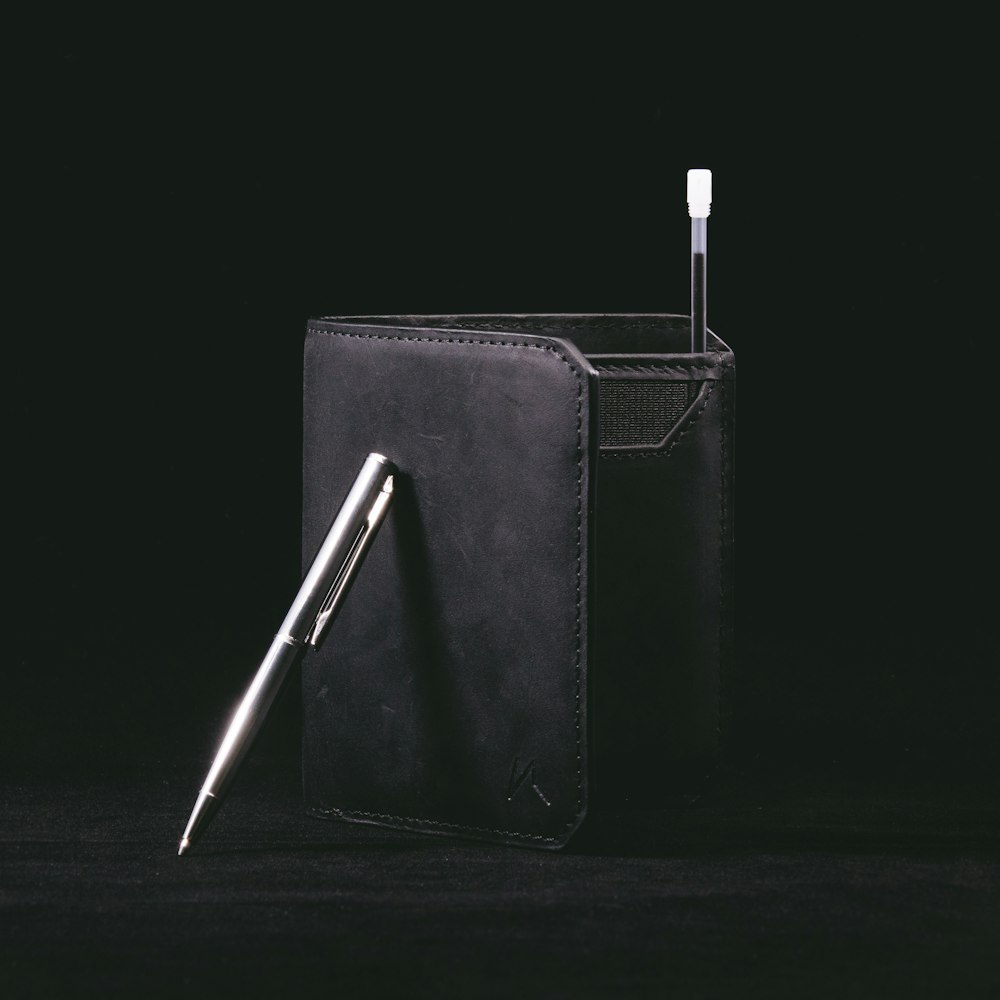 black leather bifold wallet with pen