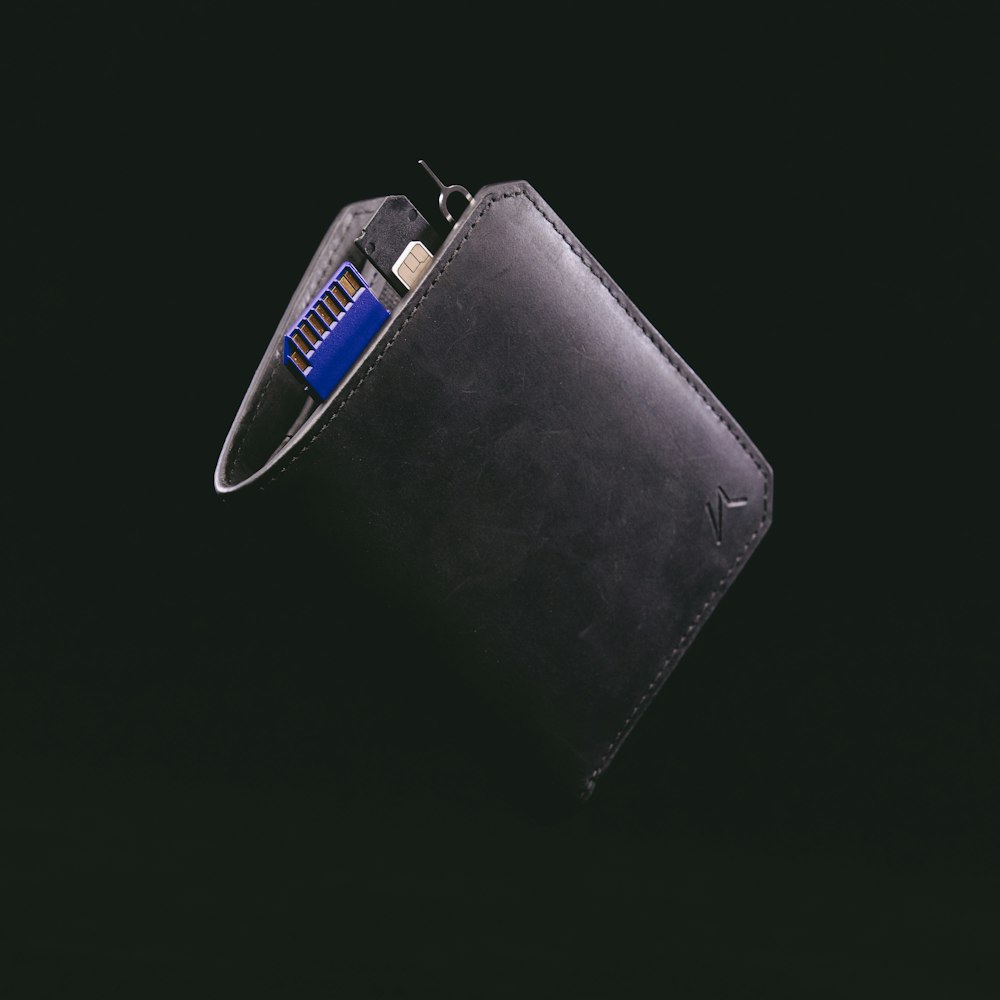 black leather bifold wallet with blue and silver key