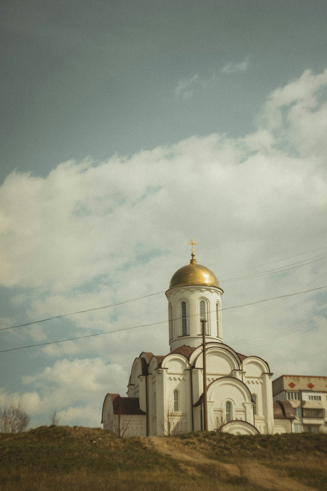 brown and white concrete church under white clouds