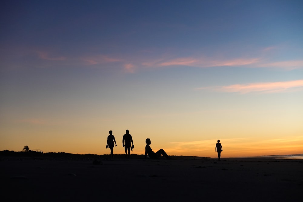 silhouette of people on beach during sunset