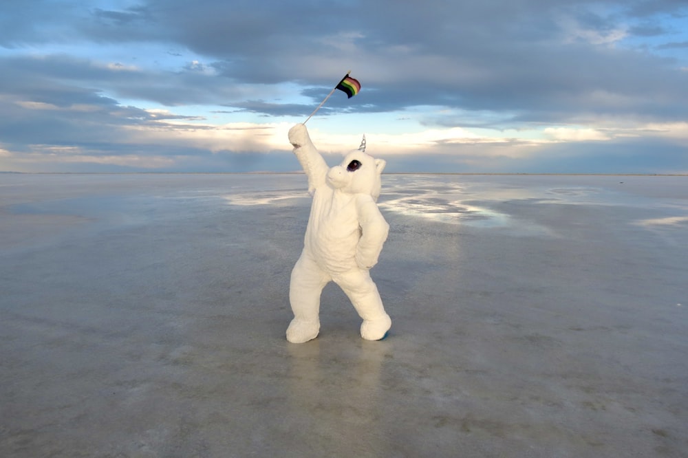 white polar bear holding blue and white umbrella