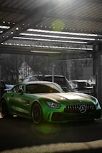 A welcoming garage entrance with a shiny repaired car parked outside under warm sunlight.