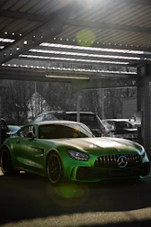 Shiny vehicle with freshly tinted windows reflecting sunlight in a modern garage.