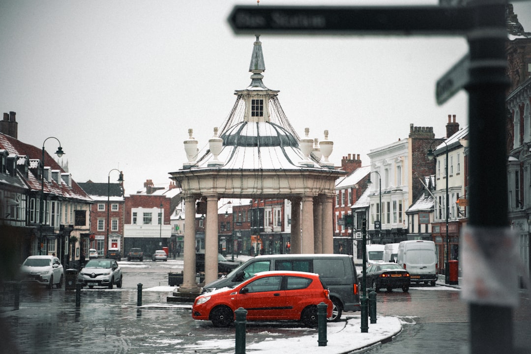 red car on road near building during daytime