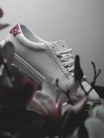 Veloura sneakers in soft blush pink captured on a minimalist white background with subtle gold highlights.