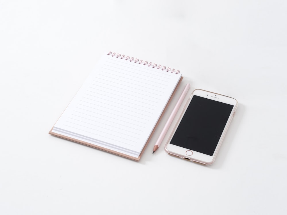 white smartphone on white notebook