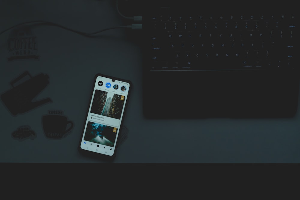 a cell phone sitting on top of a desk next to a keyboard