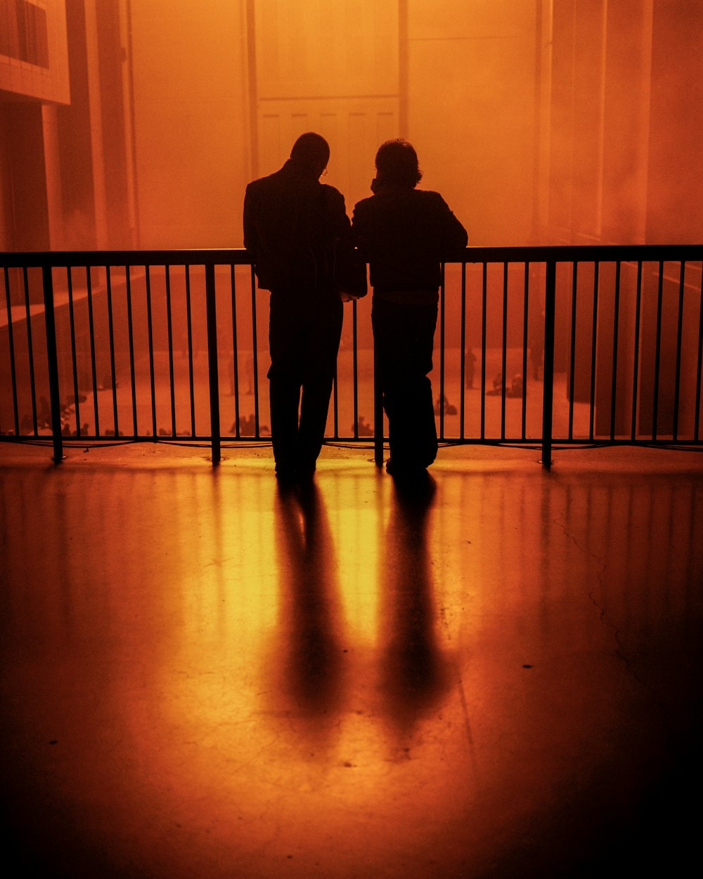 silhouette di 2 uomini in piedi sul pavimento di legno marrone