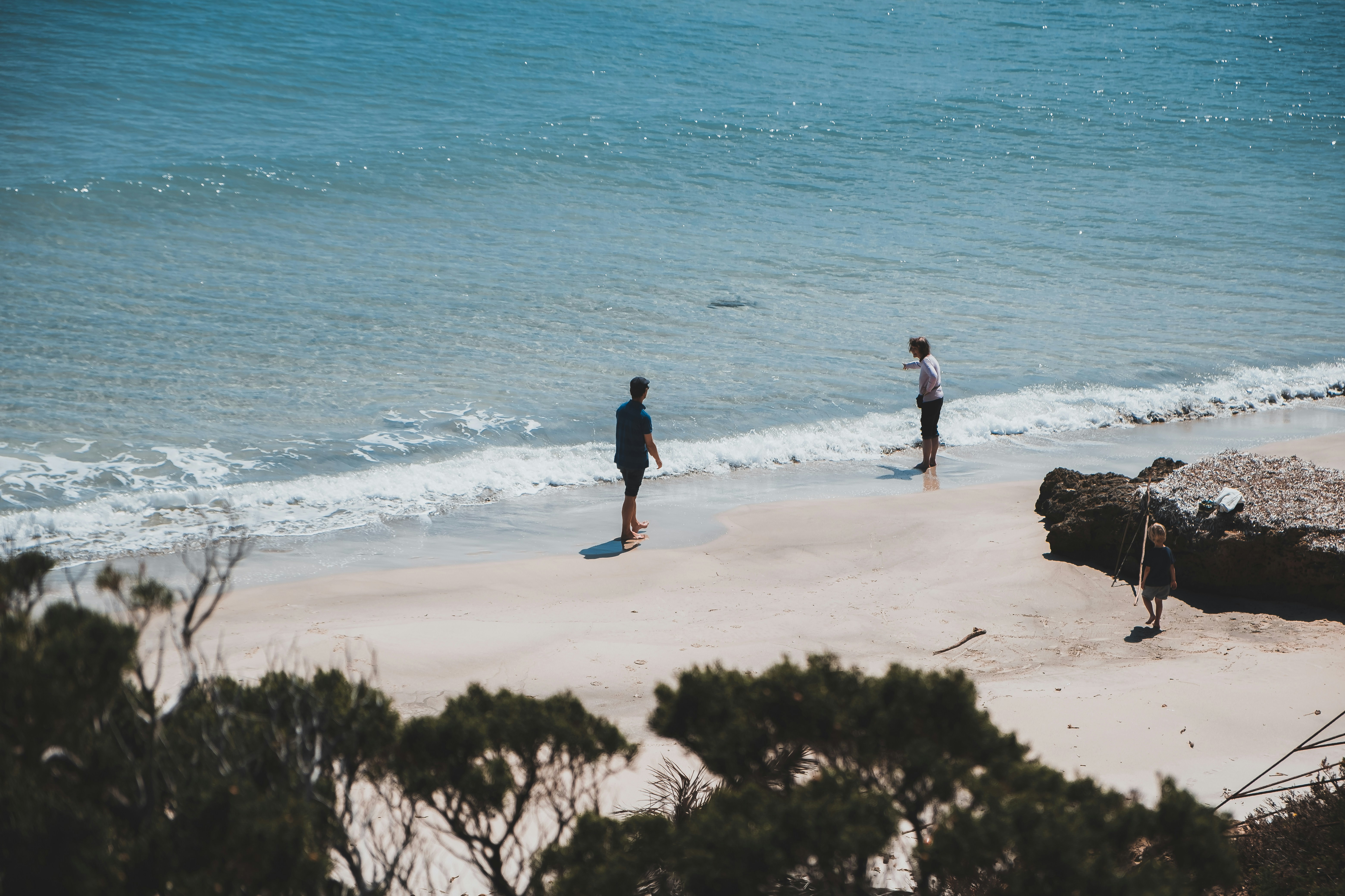 man in black jacket walking on seashore during daytime