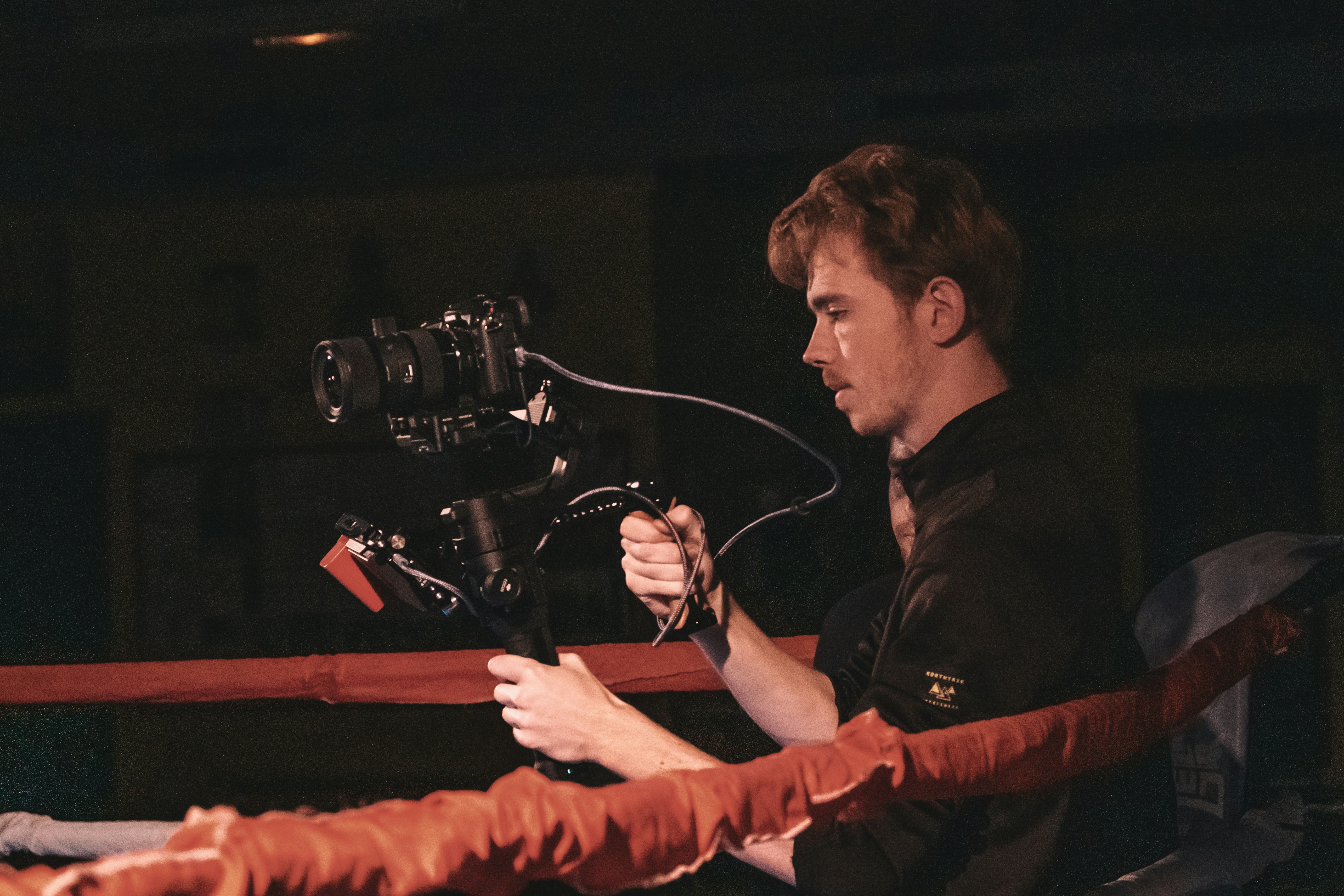 Mann in schwarzem Langarmhemd mit schwarzer und silberner Kamera