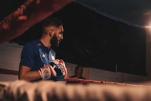 Close-up of a boxer throwing a punch in a dimly lit ring
