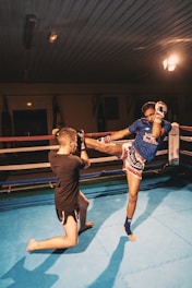 man in black tank top and shorts holding woman in blue tank top