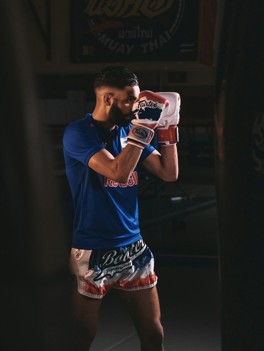 man in blue nike crew neck t-shirt and red and white shorts holding red and