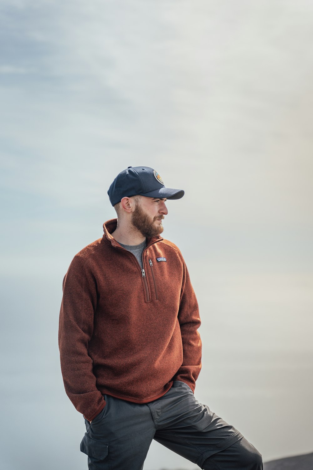 man in brown zip up jacket and black cap