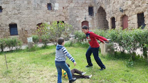 Children playing safely in a green courtyard surrounded by sustainable housing units.