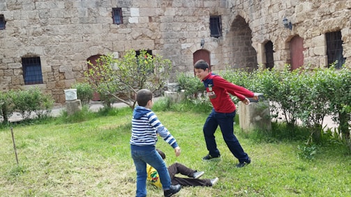 Children playing in a safe, green courtyard of a residential complex.