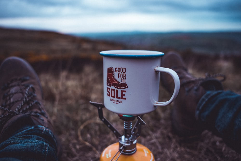 white ceramic mug on brown wooden stand