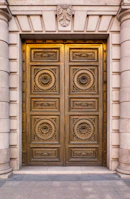 Sturdy metal door with intricate design details in a commercial setting.