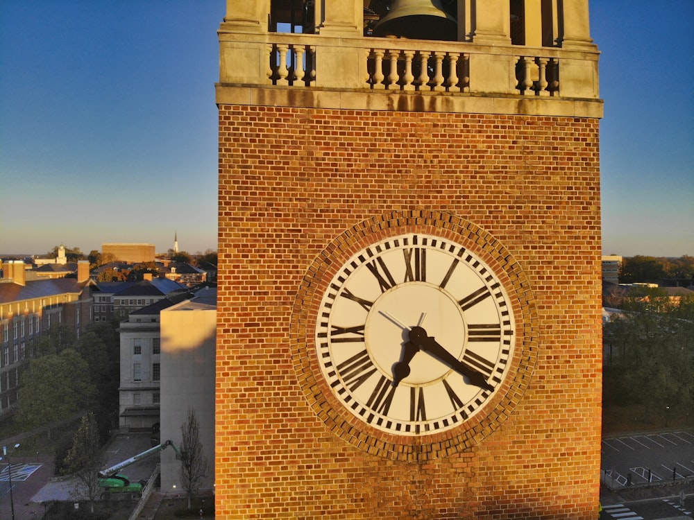 brown brick building with analog clock at 11 00