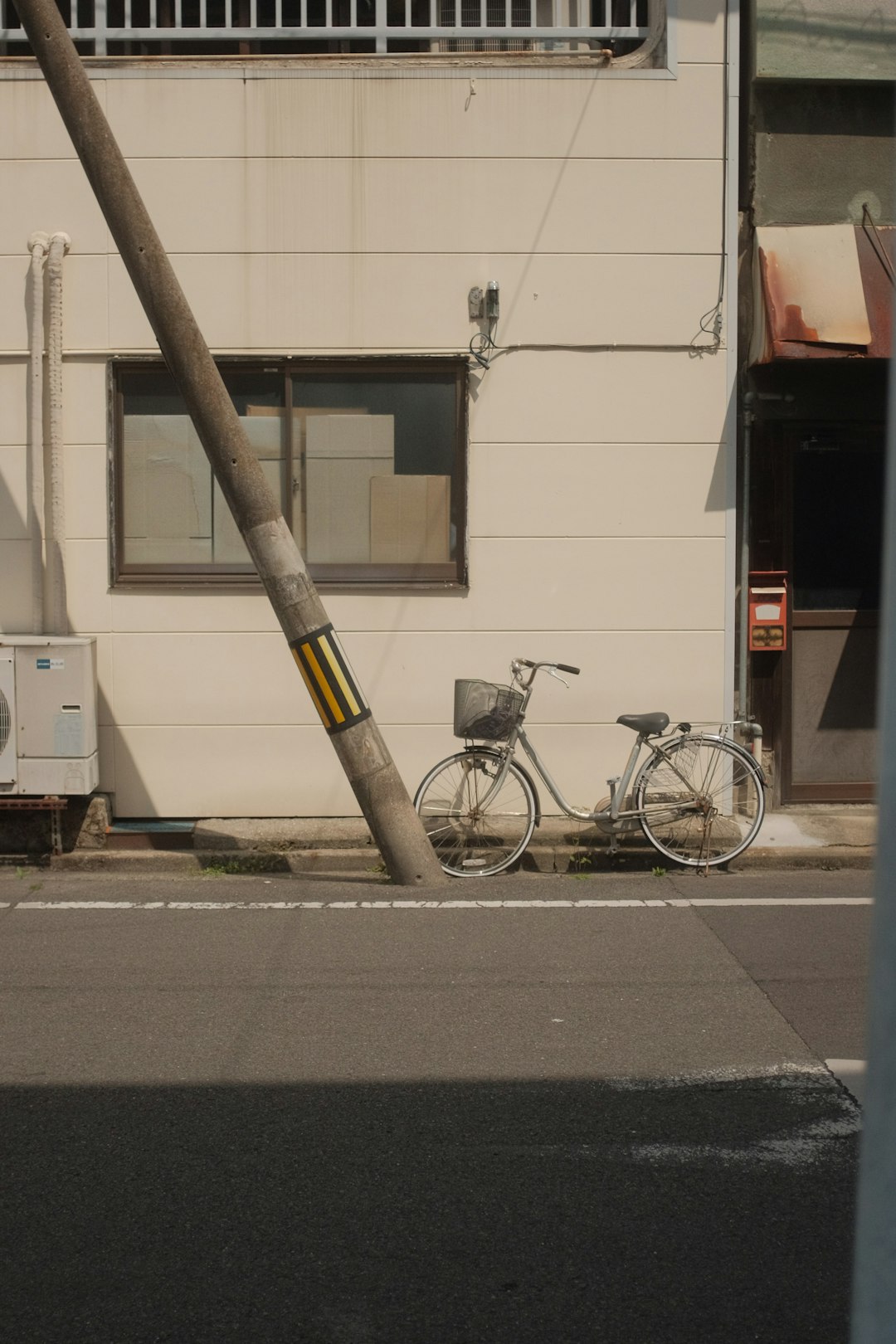 black city bike parked beside brown wooden post