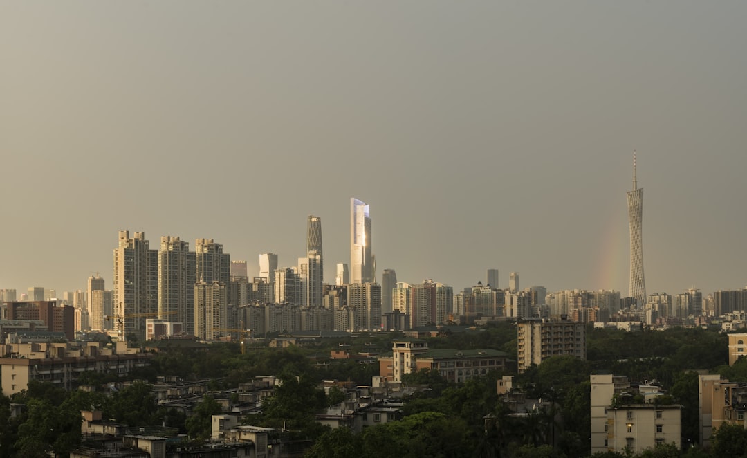 city skyline under gray sky during daytime, A panorama for the skyline of Zhujiang New Town in golden hour, with rainbow showing up around the Canton Tower.<p></figure>May 4, 2021.