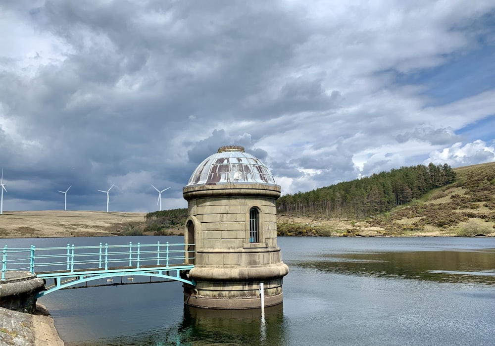 brown and white concrete building near lake under white clouds during daytime