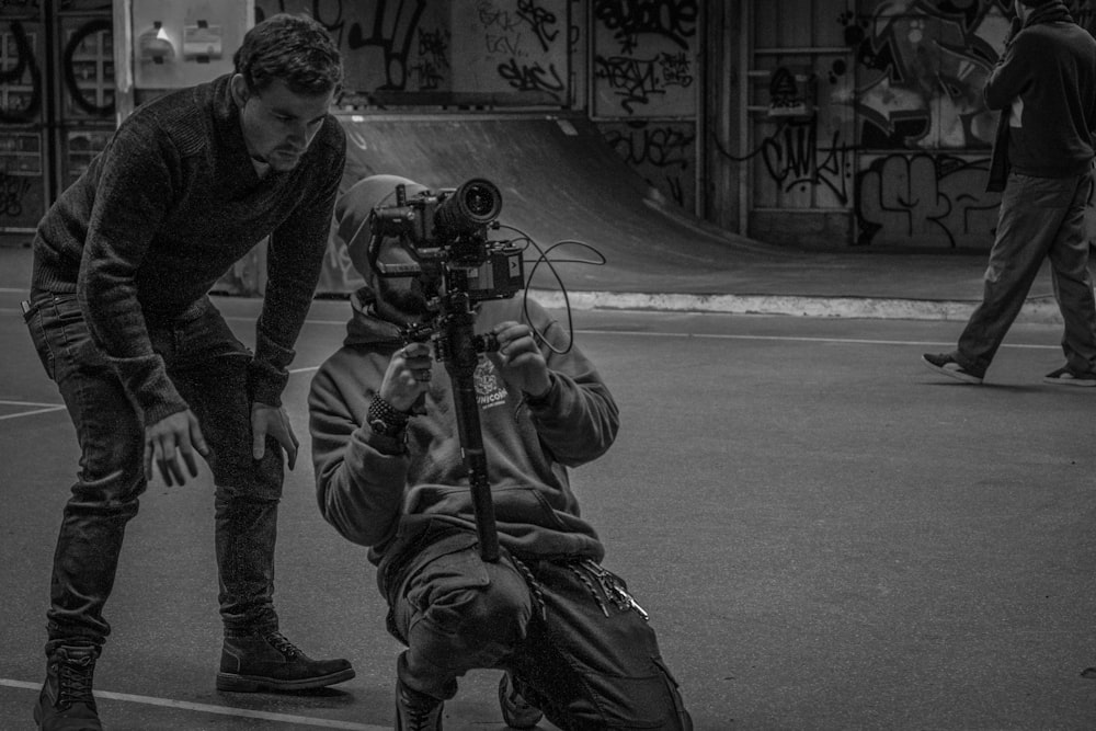 man in black jacket and pants holding black dslr camera