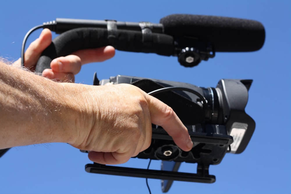 person holding black dslr camera