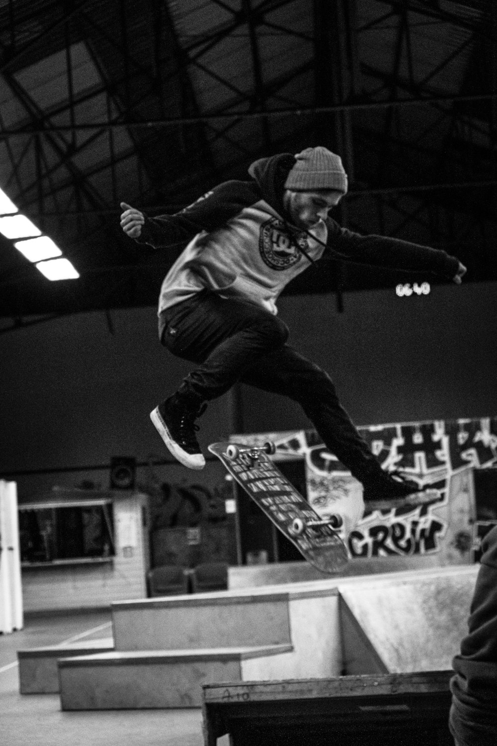 man in black jacket and blue denim jeans jumping on black skateboard