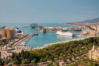 A panoramic view of Conakry's coastline showing islands and bustling port activity under a bright sky.