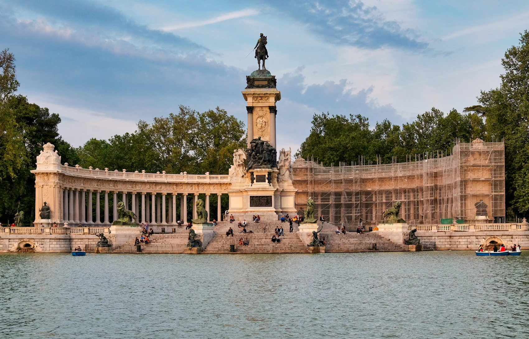 The monument and lake in El Retiro Park beneath an evening sky